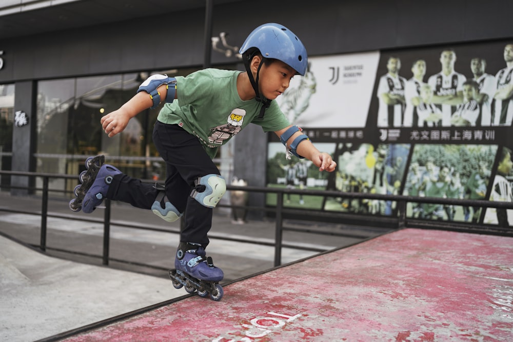 boy in green and white jersey shirt and blue helmet playing on red and black track