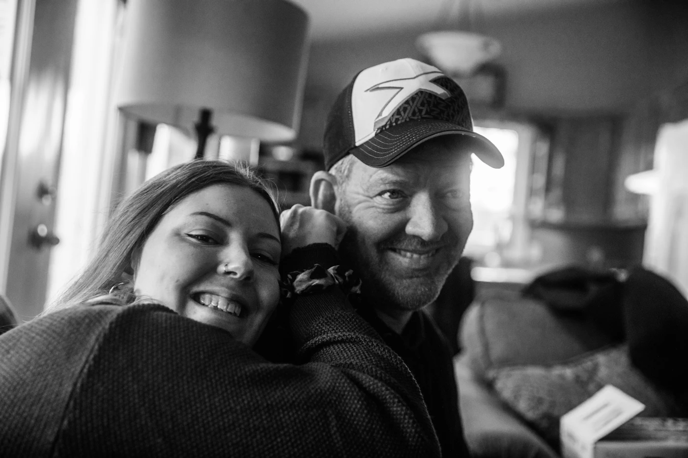 An older man and a young woman smiling together