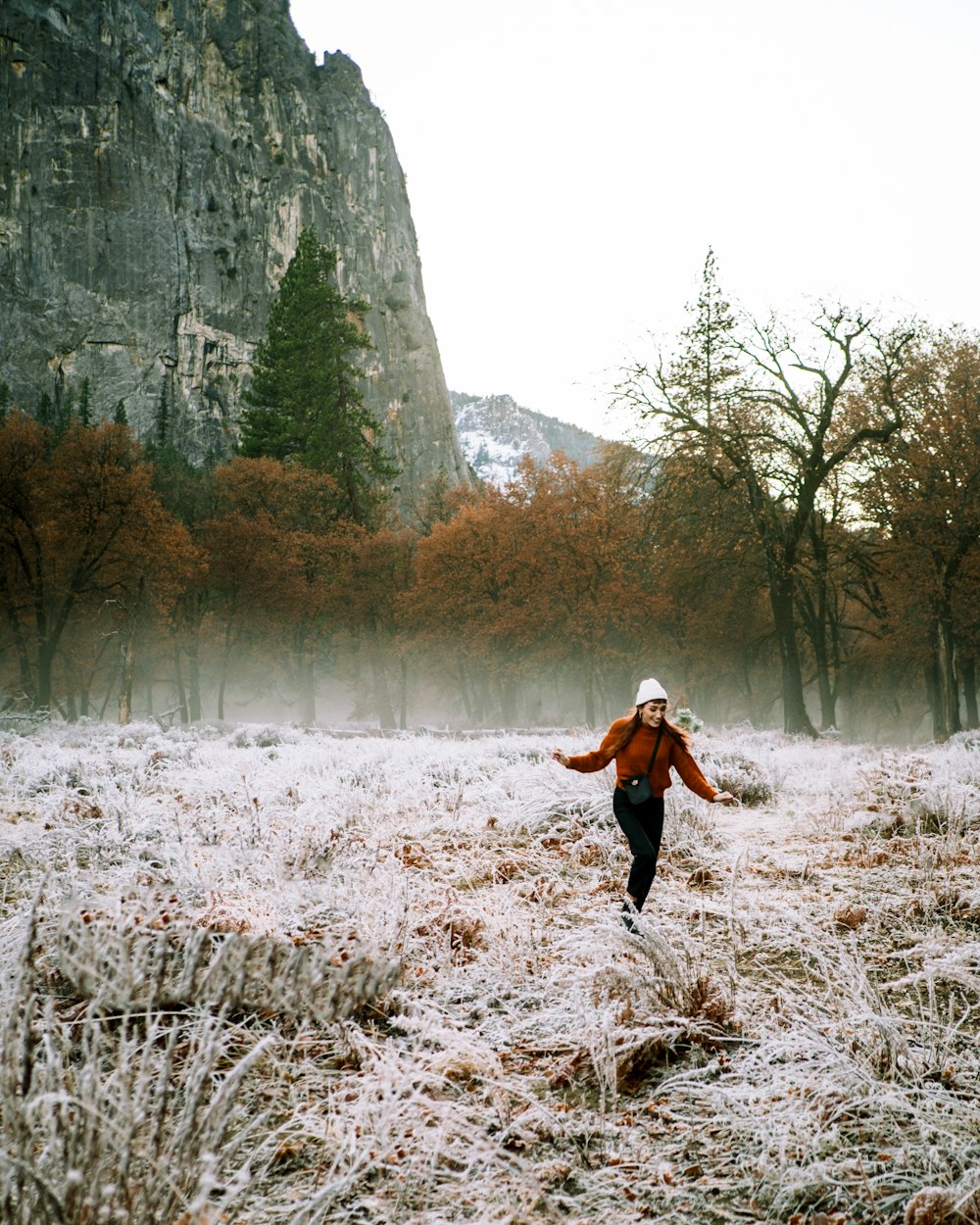 woman in black jacket and black pants running on brown field during daytime