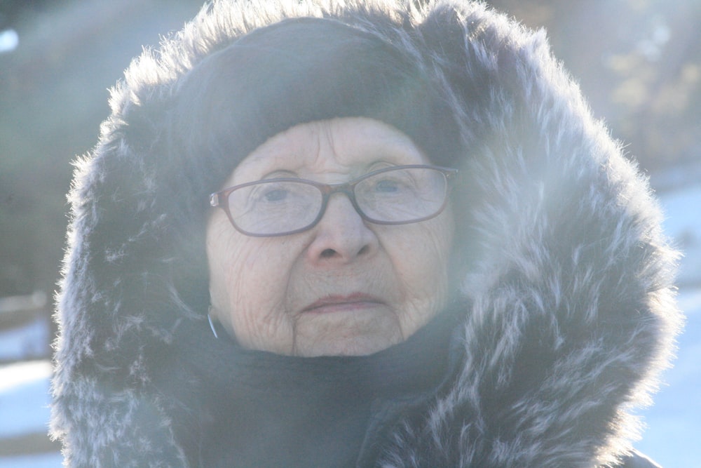 woman in black fur coat wearing black framed eyeglasses