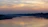 A serene river at sunset with gentle ripples reflecting the warm colors of the sky, symbolizing the river mouth.