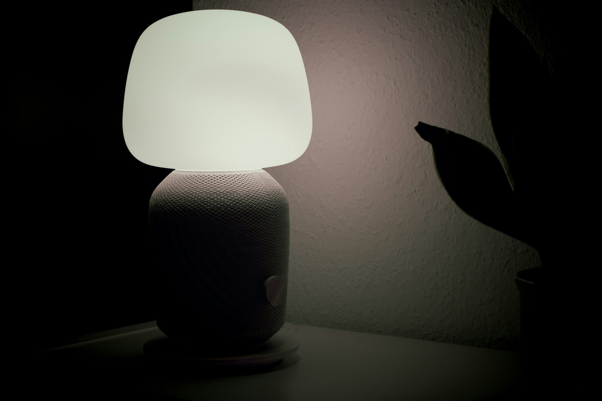 An artistic shot of a laser-cut acrylic lamp glowing softly in a dimly lit room.