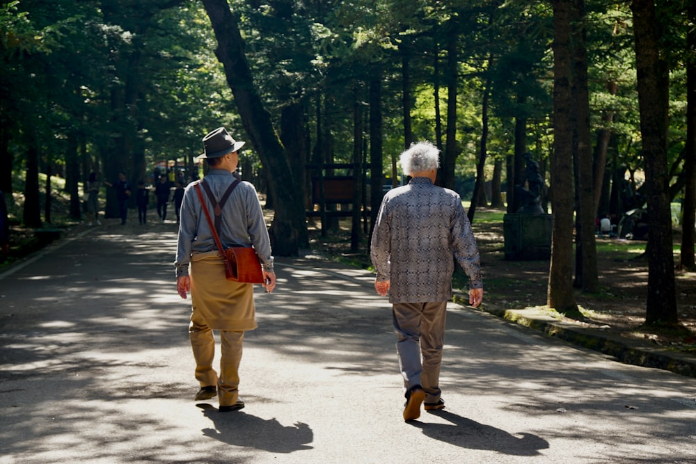 man in blue and white plaid dress shirt and brown pants walking on gray concrete road