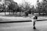 grayscale photo of child walking on road