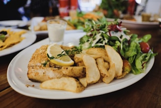 A cozy restaurant interior with a plate of crispy fish and chips on the table.