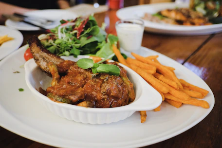 A hearty homemade red bean burger with fresh greens and a side of crispy sweet potato fries.