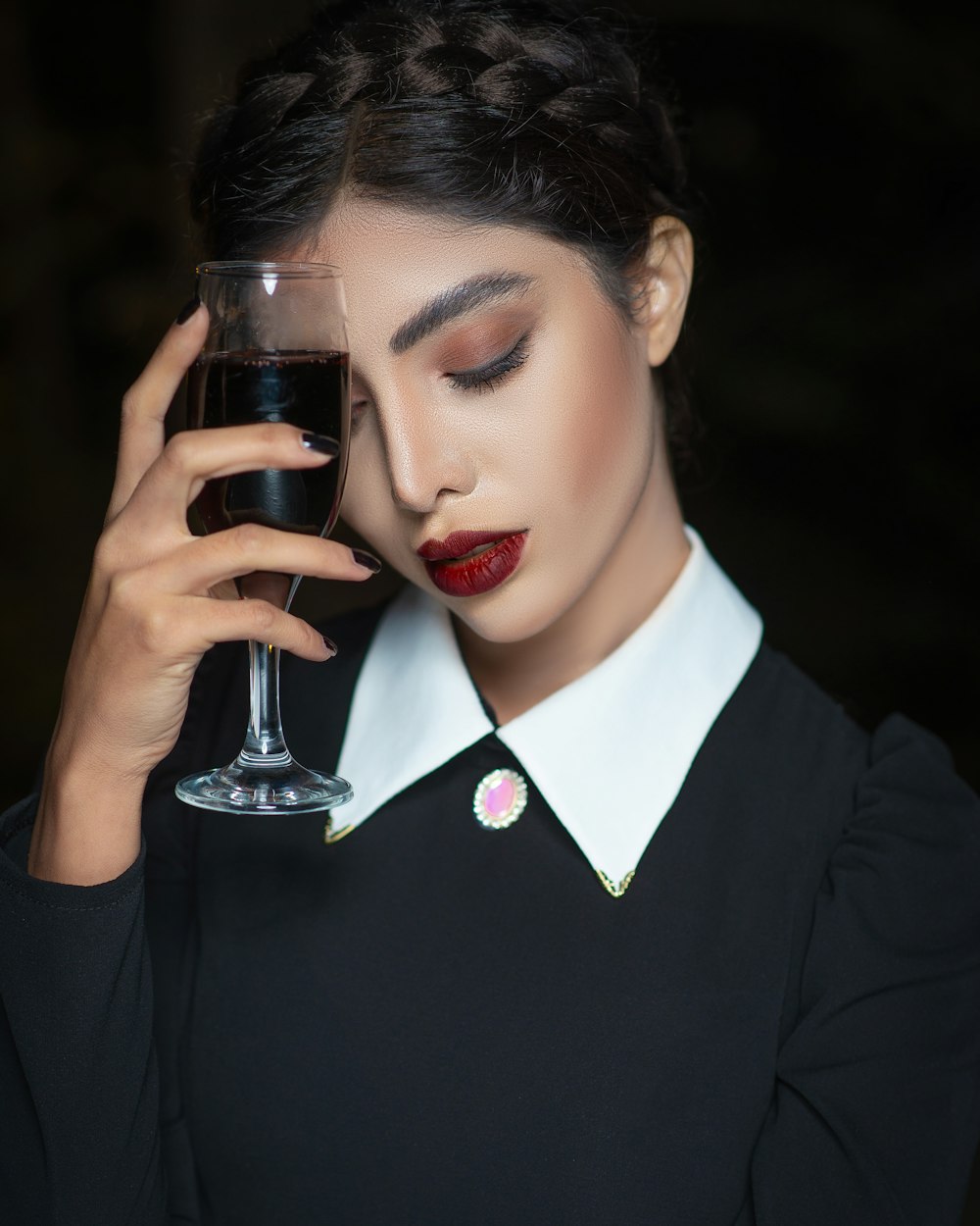 woman in black blazer holding clear wine glass