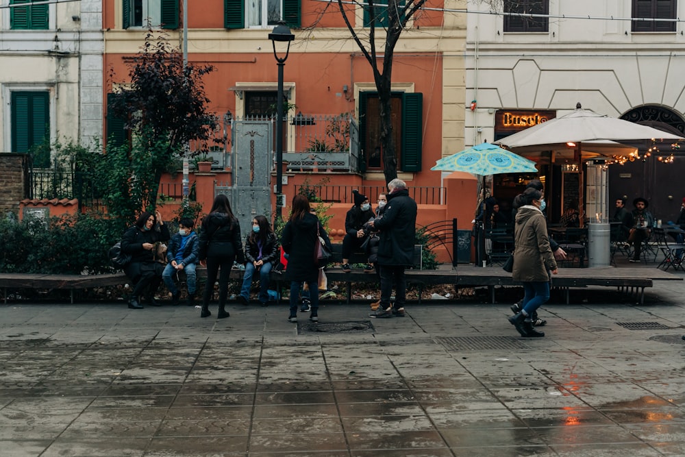 people sitting on bench near building during daytime