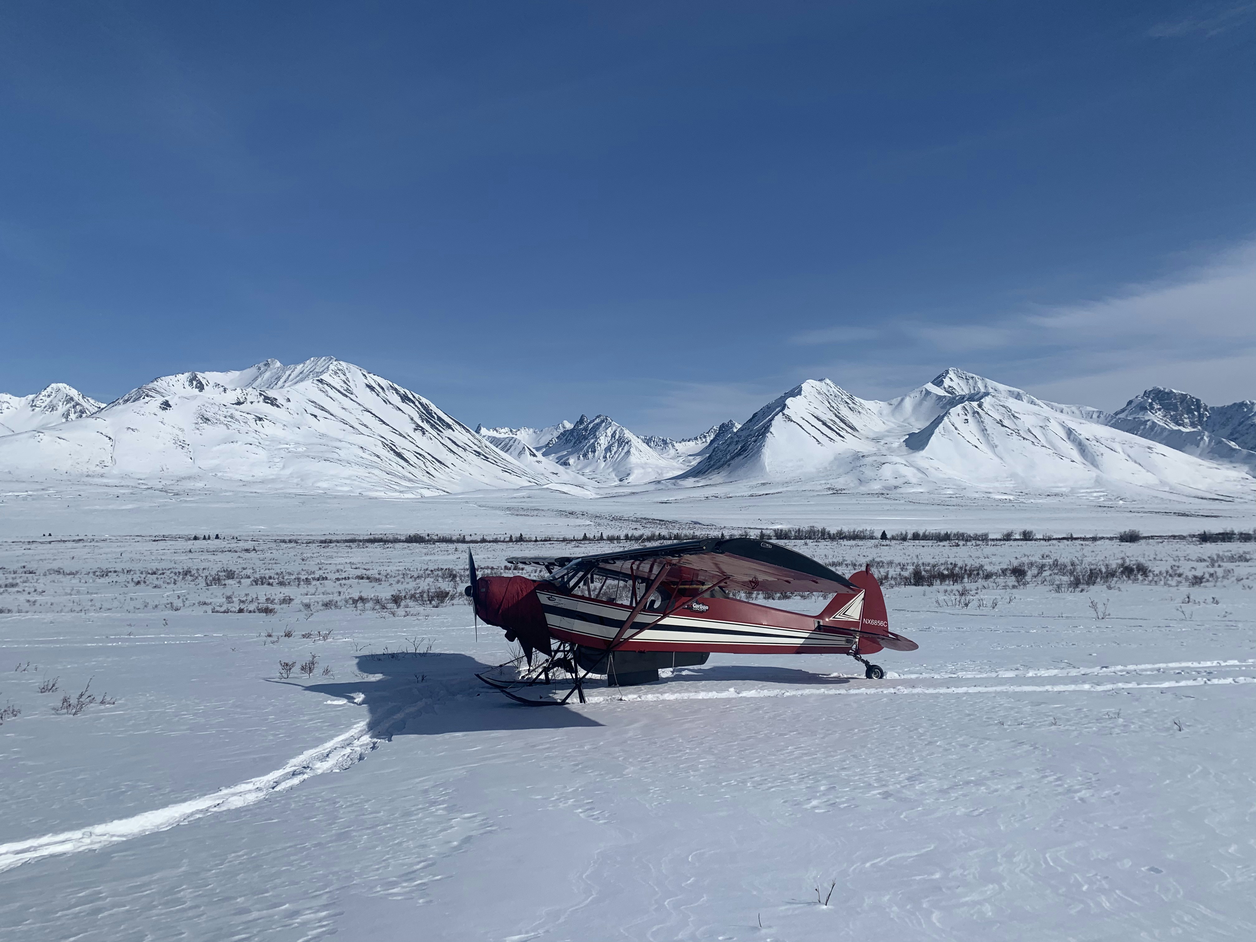 red and black boat on snow covered ground during daytime