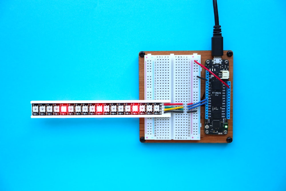 a breadboard with a thermometer and a soldering tool