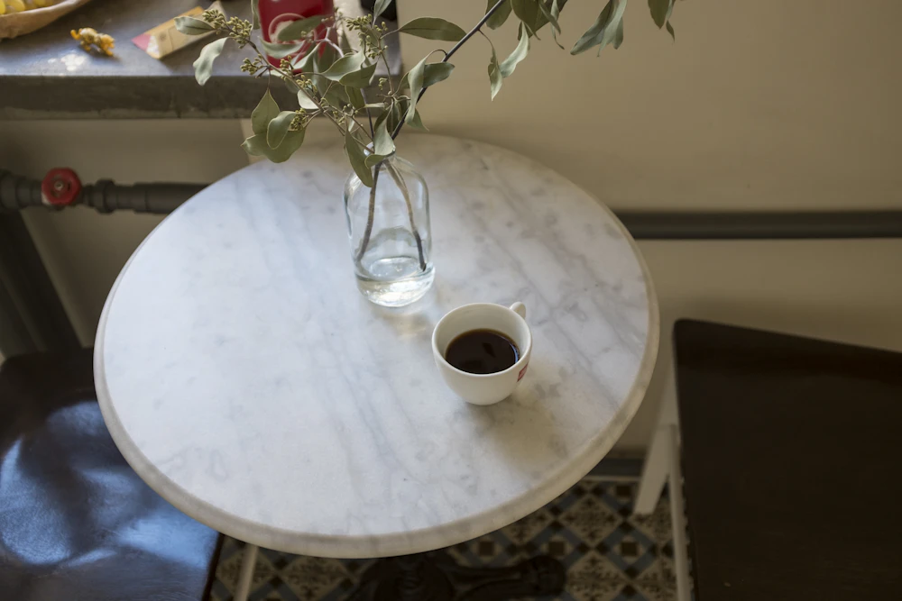 Taza de café sobre una mesa redonda de mármol