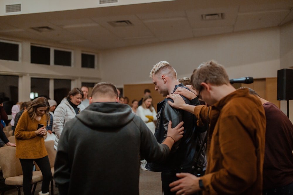people in black and brown jackets standing to pray