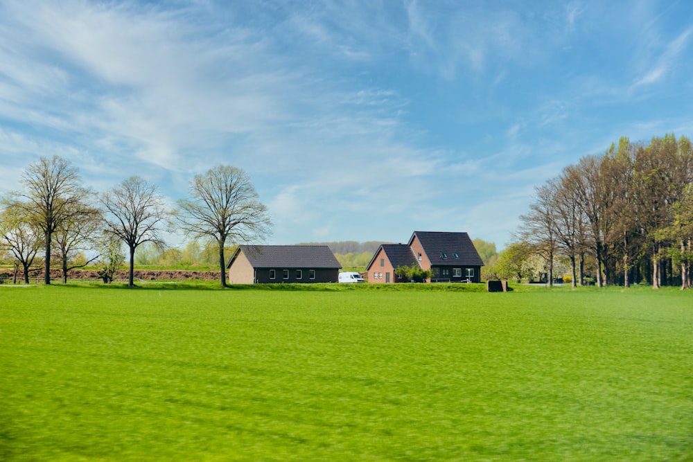 brown and gray house on green grass field under blue sky during daytime