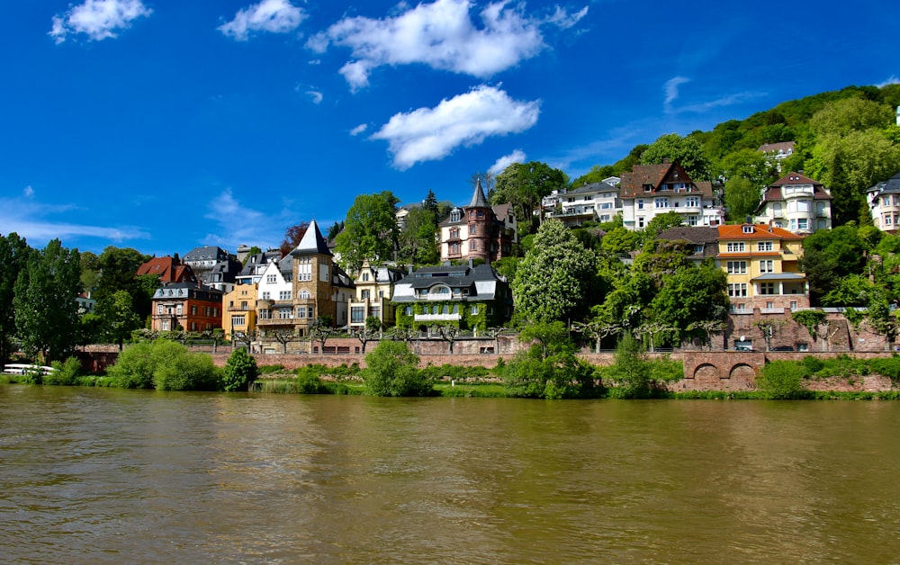 houses near river under blue sky during daytime