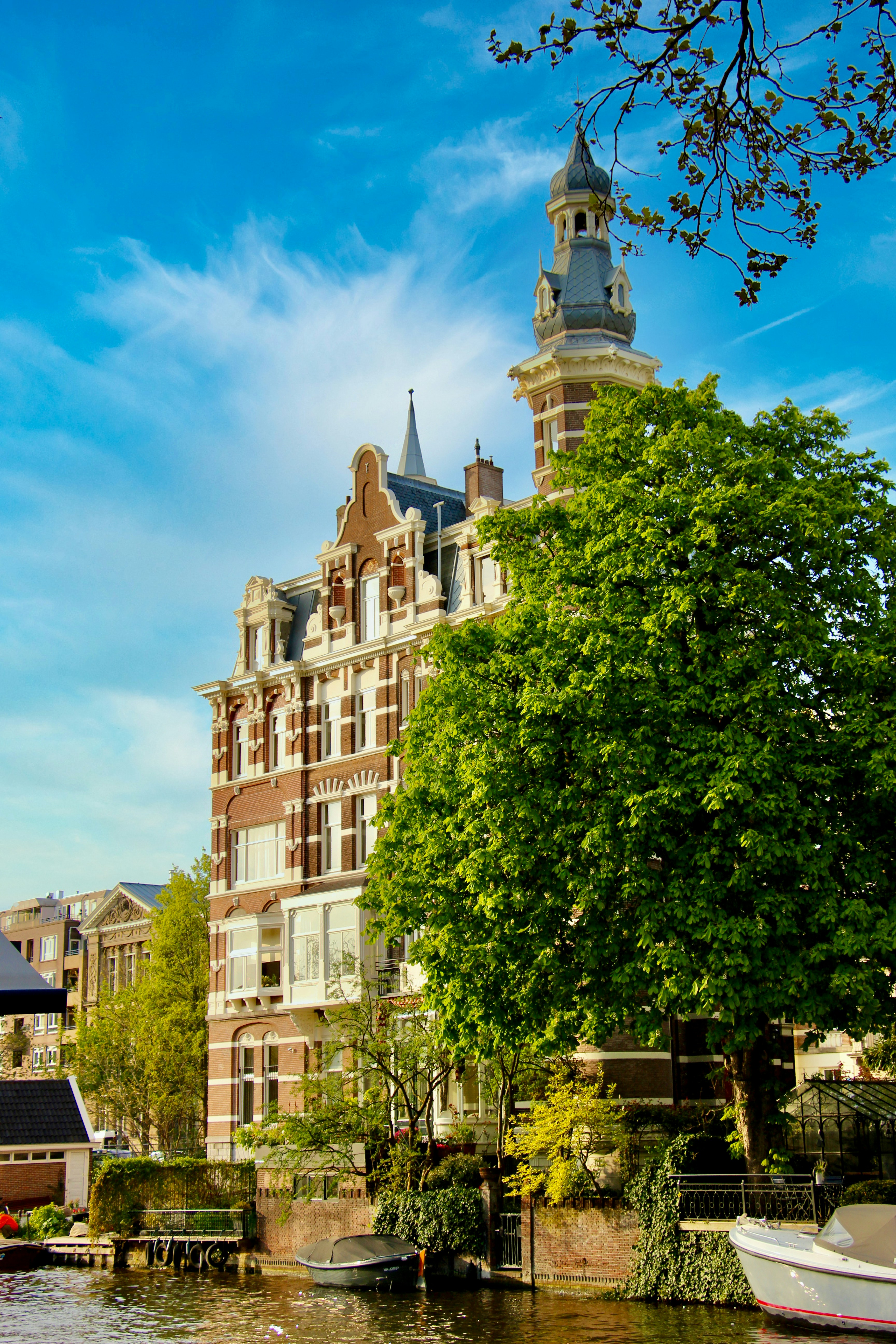 Braunes Betongebäude in der Nähe von grünen Bäumen unter blauem Himmel tagsüber