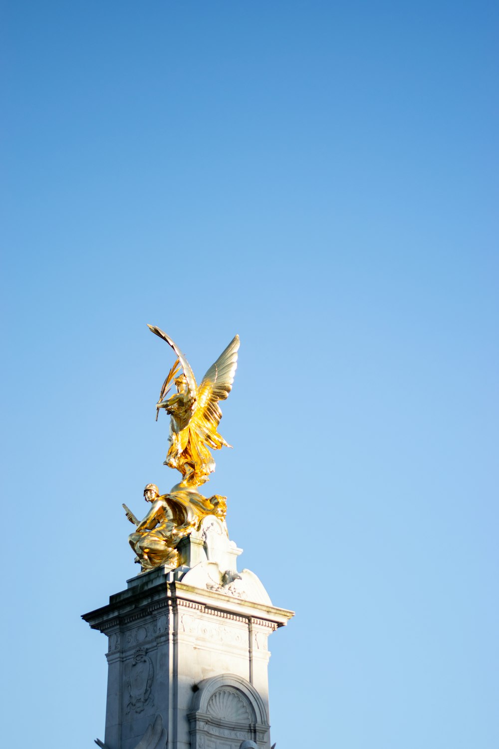 gold angel statue under blue sky during daytime