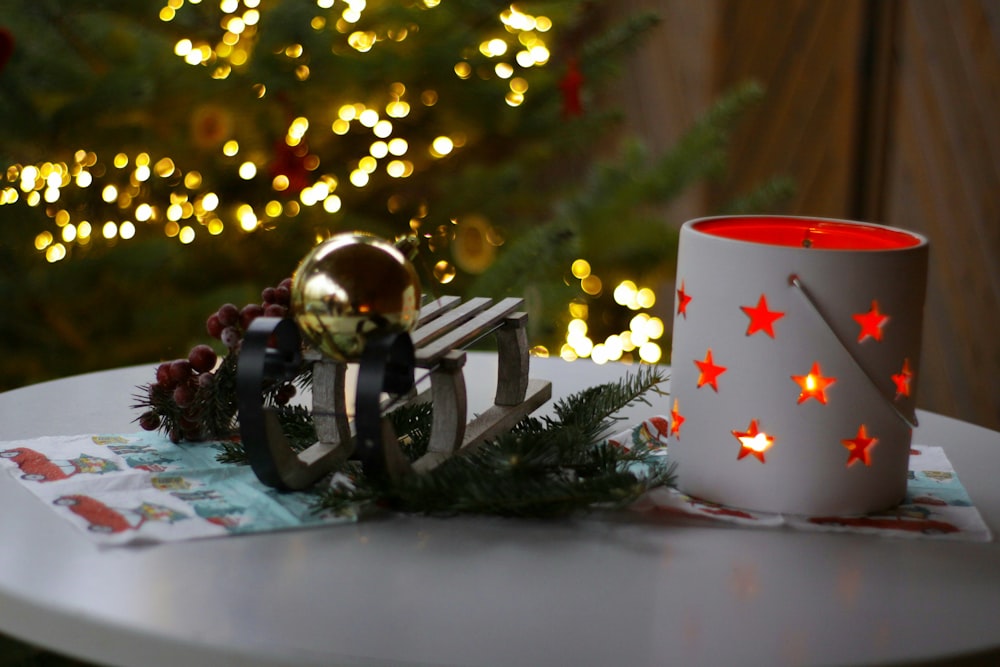 red and white ceramic mug beside black and gold bell