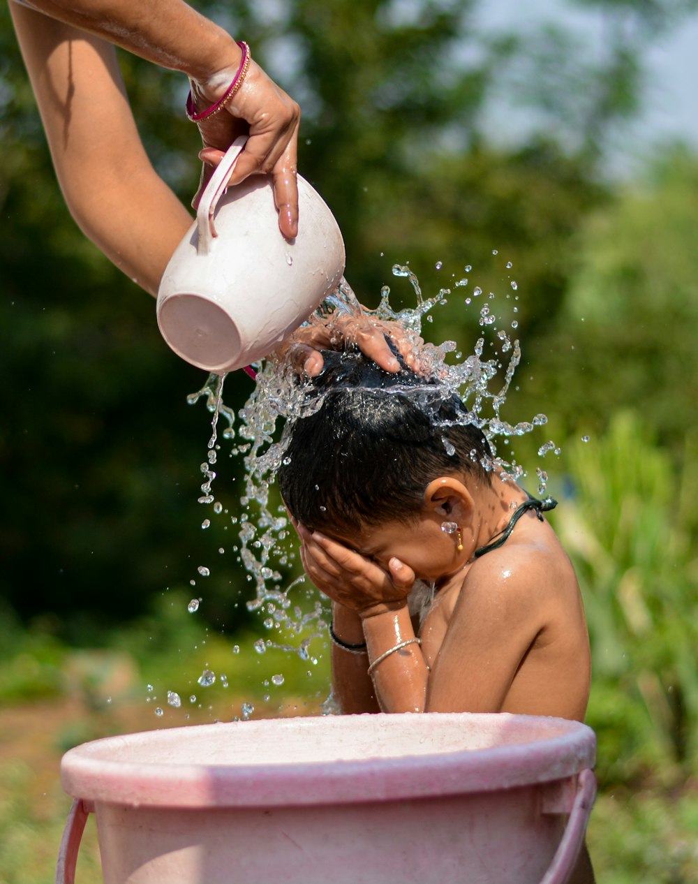 woman in white tank top pouring water on white ceramic mug