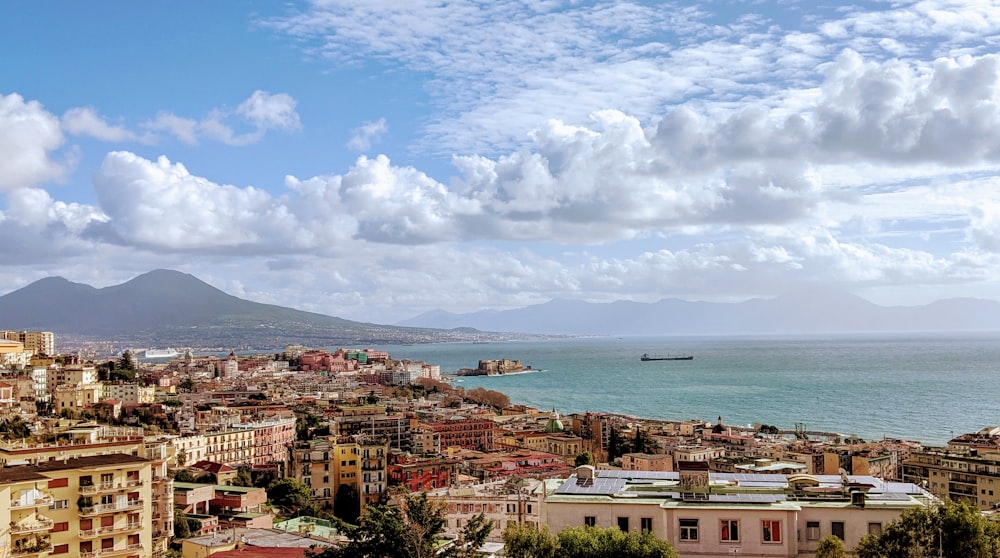 edifícios da cidade perto do mar sob nuvens brancas e céu azul durante o dia