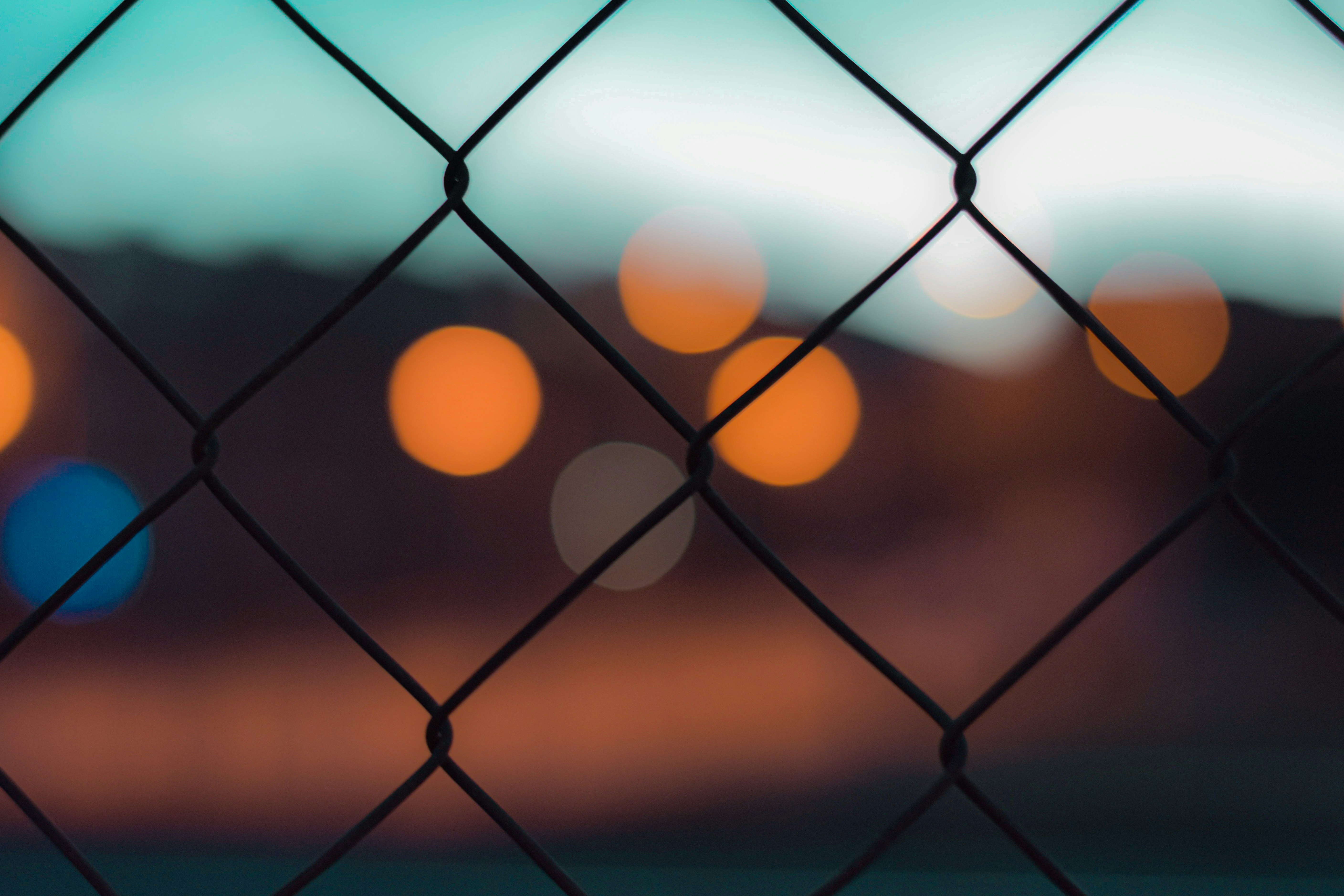 bokeh photography of gray metal fence during night time