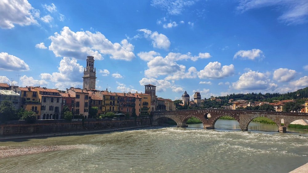 brown concrete bridge over river under blue sky during daytime