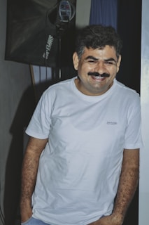 A happy customer wearing a personalized t-shirt in a cozy studio setting.