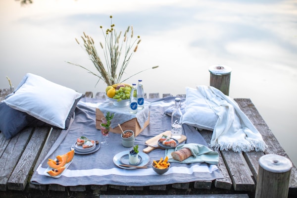 A serene outdoor scene featuring a picnic setup with oils and natural products.