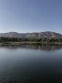 Serene lake view near Managua with reflection of surrounding hills and clear blue sky.