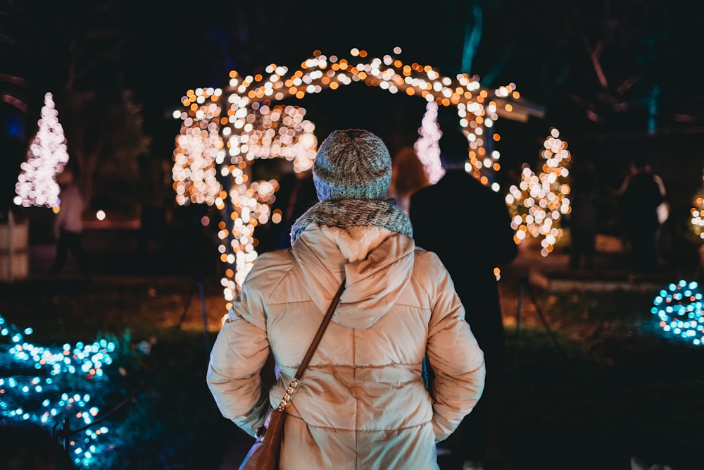 man in brown jacket holding lighted sparkler