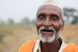 An elderly man smiling while a caregiver assists him with a morning walk in a garden