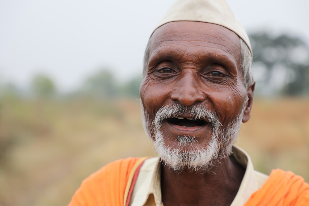 man in orange and white shirt smiling