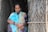 woman in white and green sari holding brown wooden stick