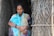 woman in white and green sari holding brown wooden stick