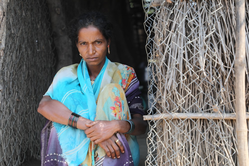 woman in white and green sari holding brown wooden stick