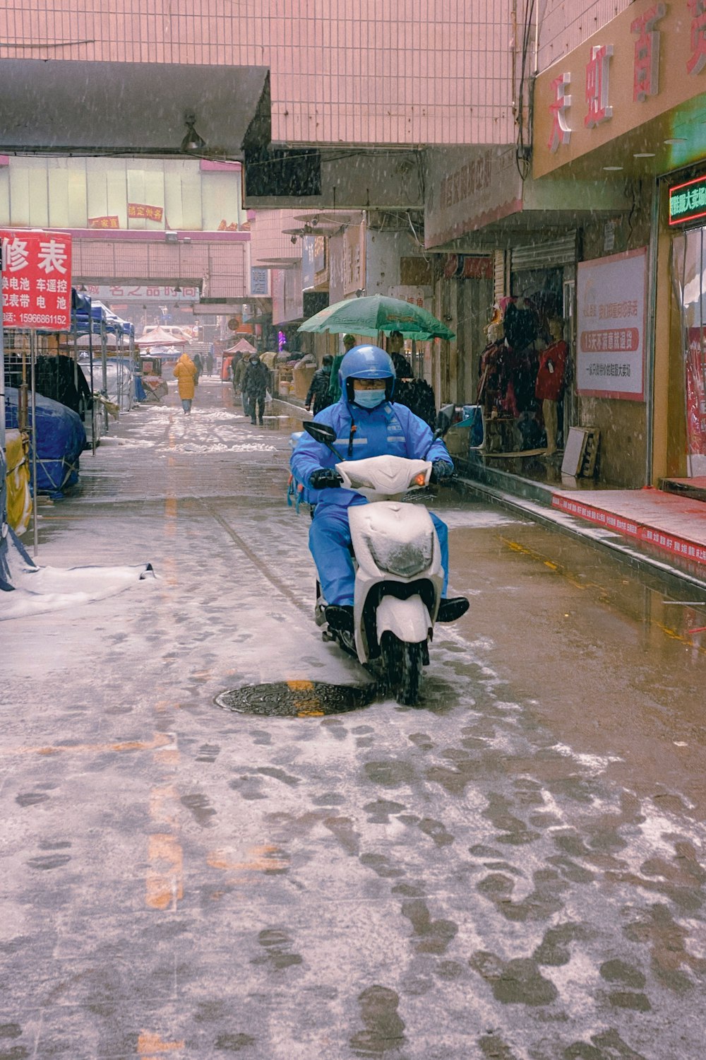 person in black jacket riding on black and white motor scooter on road during daytime