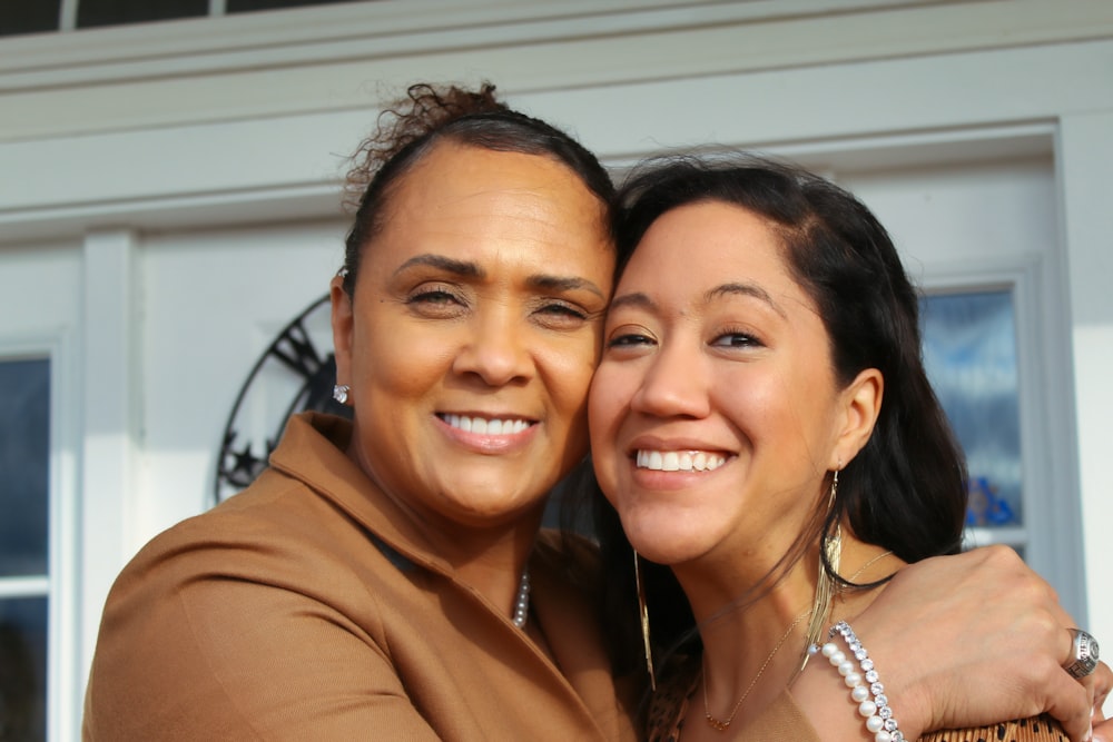 woman in brown shirt smiling beside woman in brown shirt