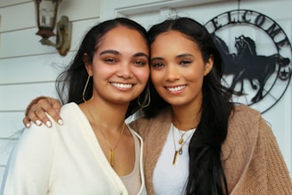 woman in white v neck shirt beside woman in brown cardigan