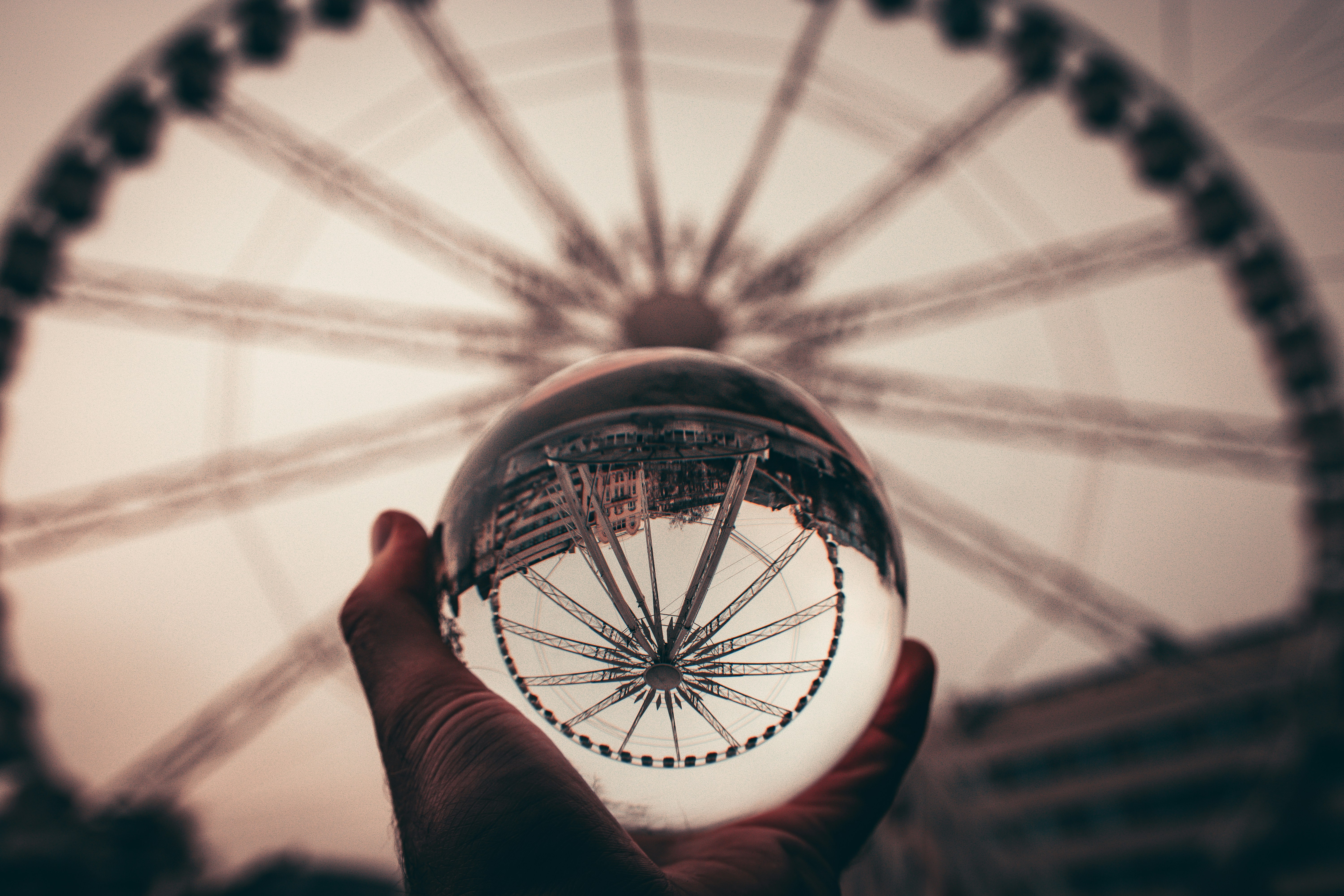 person holding round glass ball