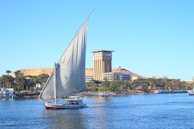 white sail boat on water near city buildings during daytime