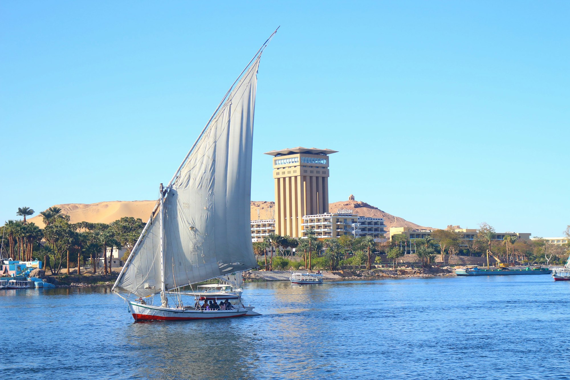 white sail boat on water near city buildings during daytime