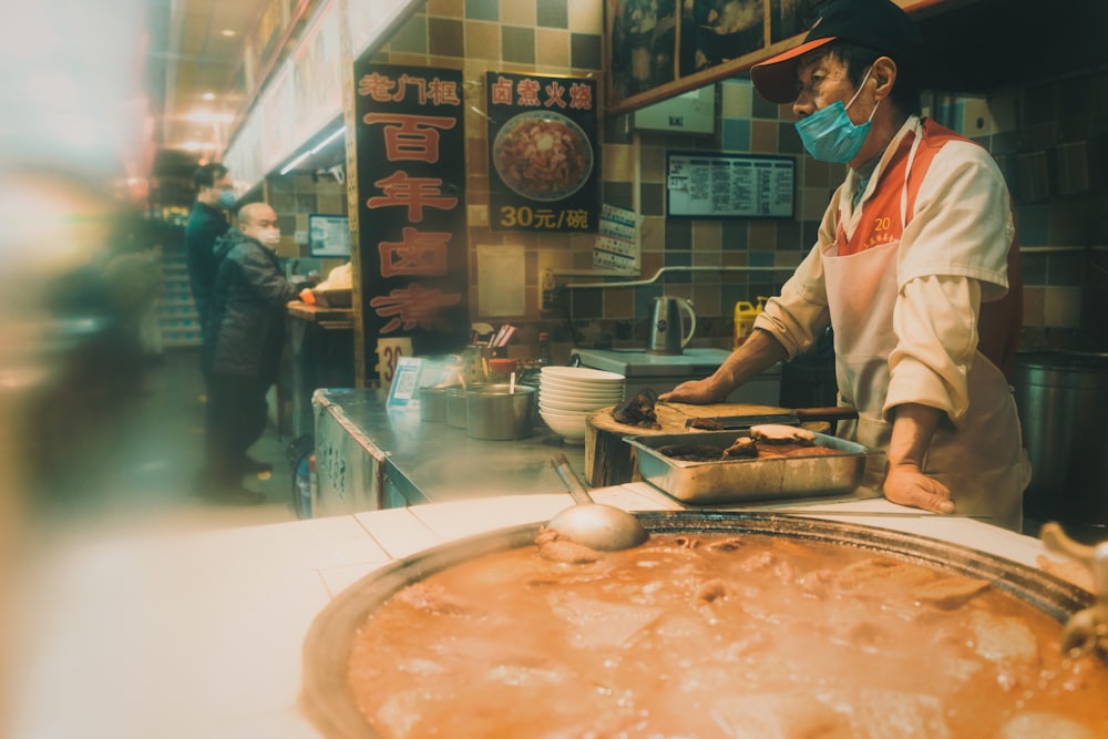 man in white chef uniform holding chopsticks