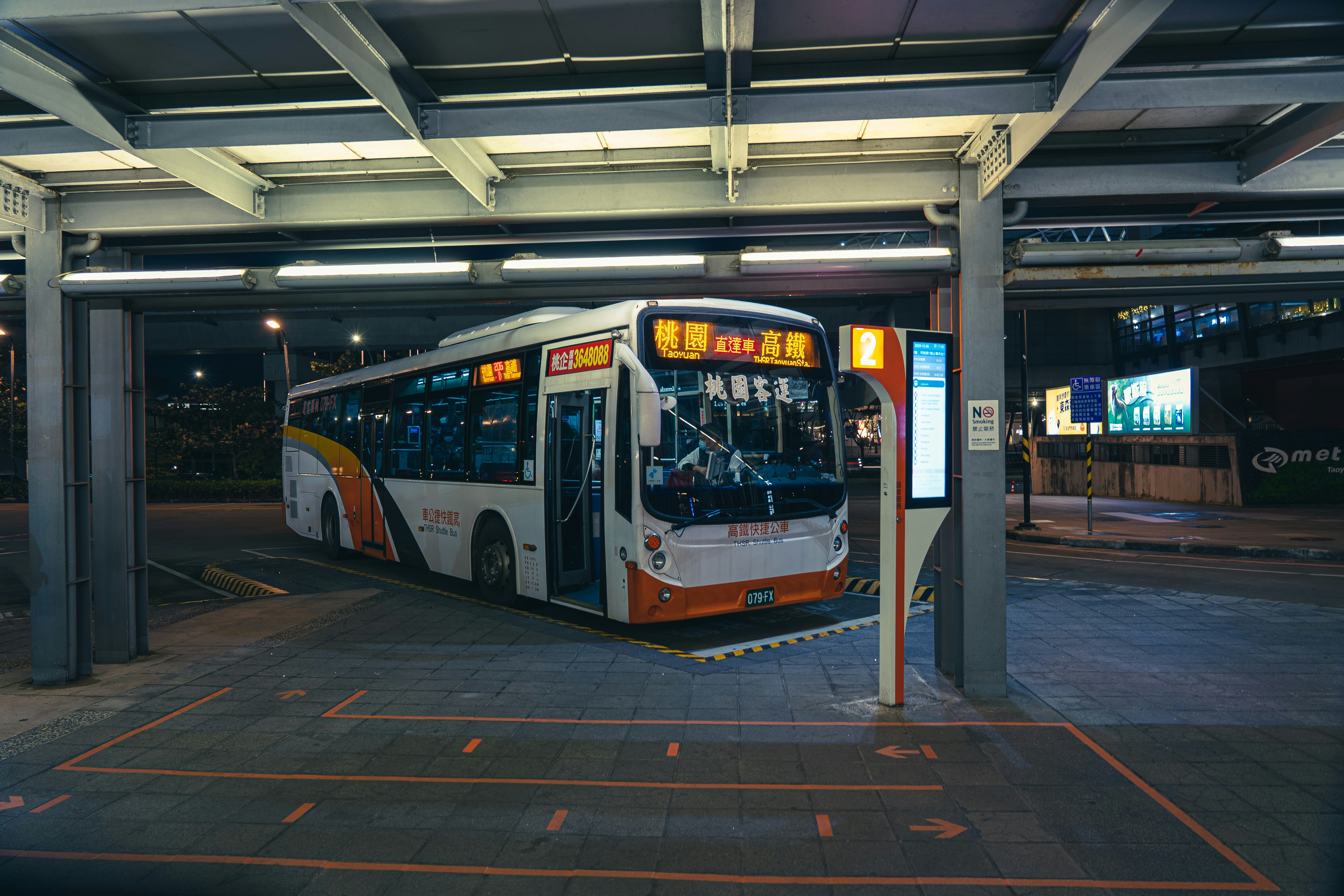 red and white bus on gray concrete floor