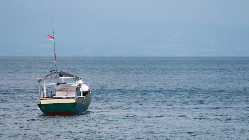 red and white boat on sea during daytime