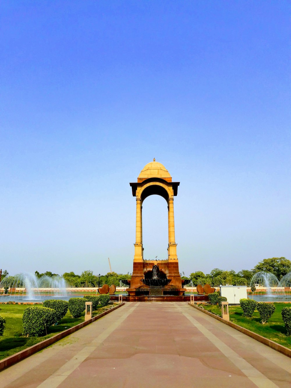 brown concrete arch near green grass field during daytime