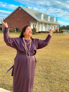 A joyful woman outdoors, arms raised in celebration of health and empowerment.
