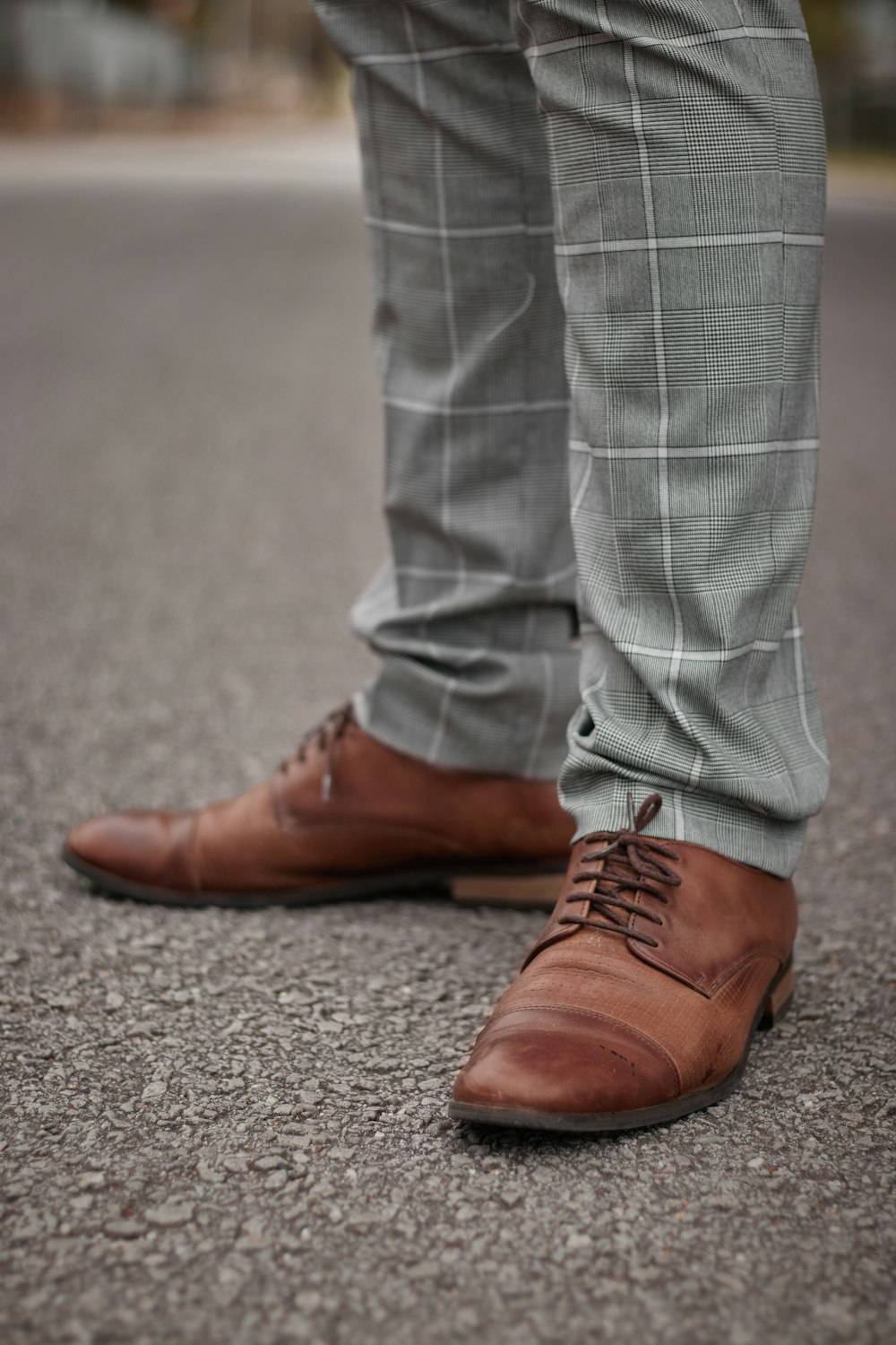 person in gray denim jeans and brown leather shoes