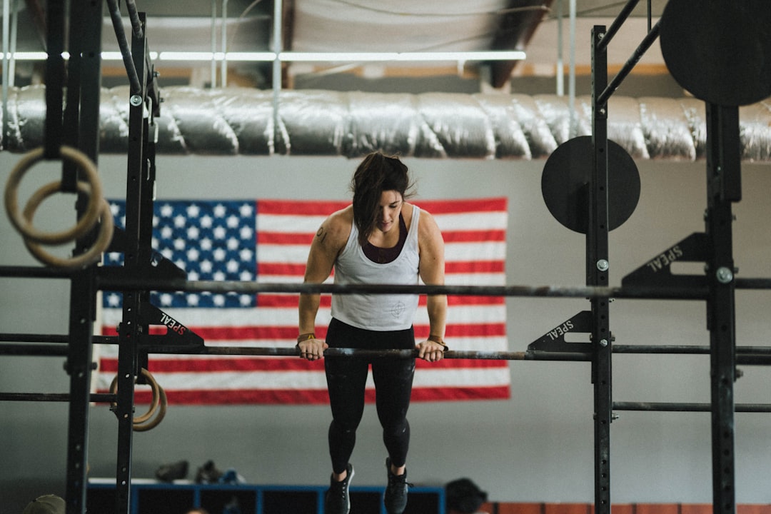 woman in gray tank top and black pants standing on red and black exercise equipment, Crossfit Competition