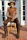 Stylish man in a straw hat standing confidently in a sunlit gym with western decor.