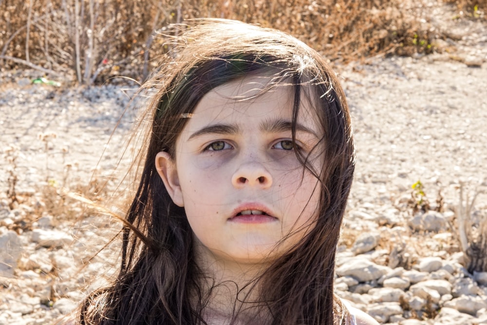 girl in black shirt lying on brown grass during daytime