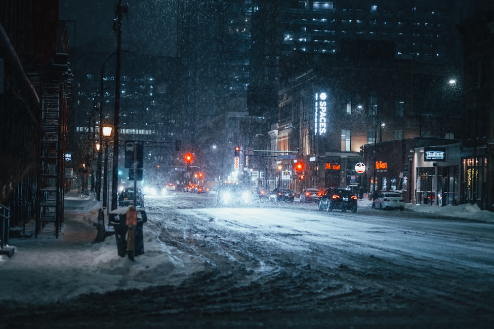 pessoa em jaqueta preta em pé na estrada durante a neve